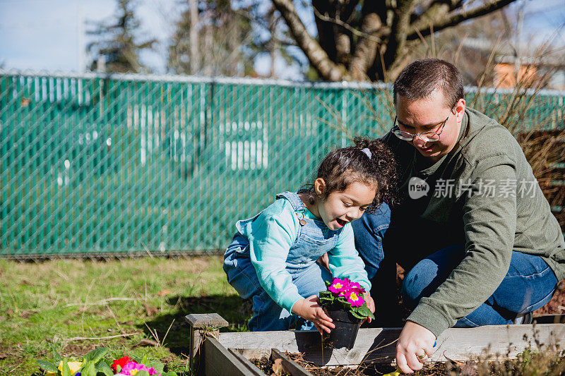 慈爱的父亲和他的小女儿在前院享受春天