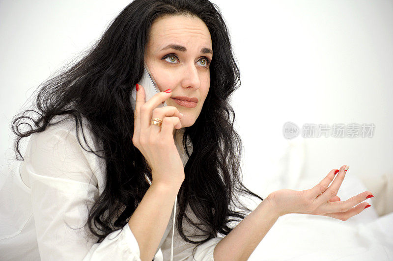 女人的脸特写在手电话不愉快的谈话情绪上抬起眼睛扭曲的嘴唇在白色的背景上文字不成功的地方不满的秩序扬起眉毛皱纹额头