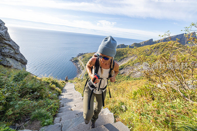 年轻女子徒步旅行在一个美丽的风景在夏天走楼梯享受大自然和户外。
罗弗敦群岛，挪威