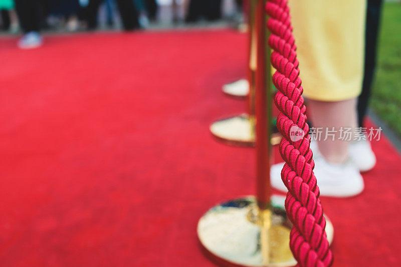 豪华派对入口系着绳索和金色护栏的红地毯，影院首映电影节活动颁奖盛典，贵客到场，户外装饰元素，夏日