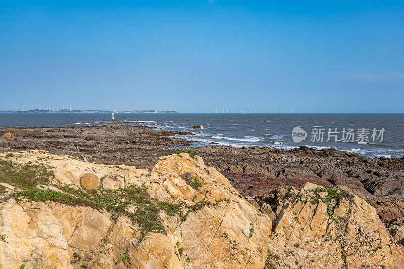 在晴朗的日子里，海边的礁石和海浪