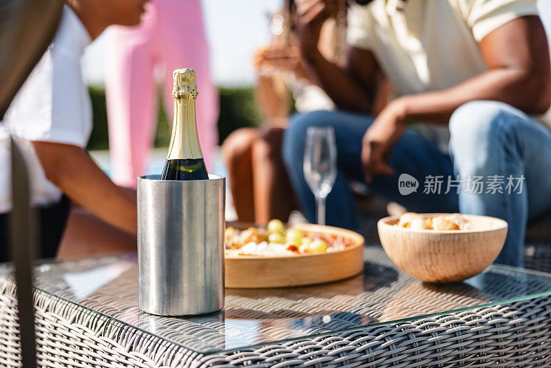 在户外夏日派对上，一瓶香槟酒在冷藏箱里和一些小吃的特写