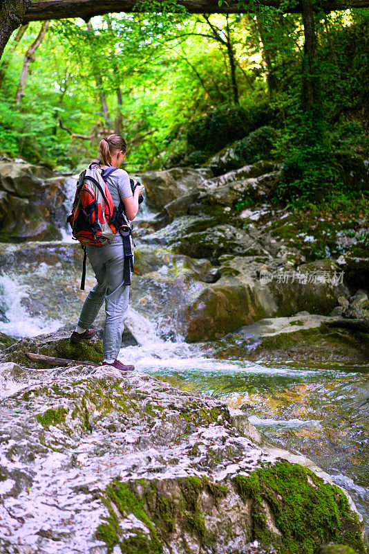 一名女子站在凉水边，凉水流经位于斯洛文尼亚中部的Smarjeske温泉区附近的小峡谷。