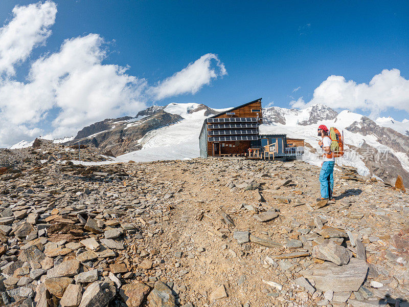 登山者到达瑞士阿尔卑斯山的山间小屋