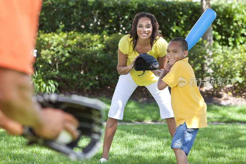 一个非裔美国家庭在院子里打棒球