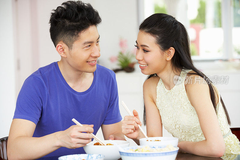 年轻的中国夫妇在家吃饭