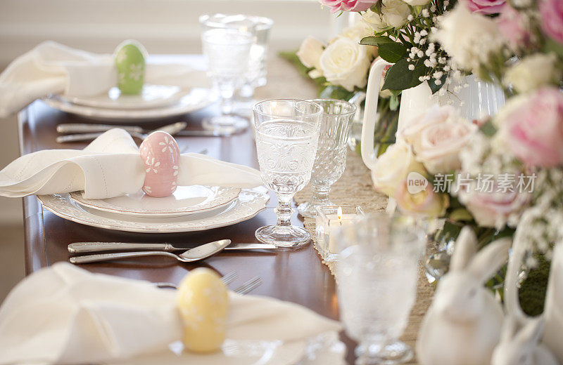 复活节优雅的餐桌上有复活节彩蛋，玫瑰和装饰品