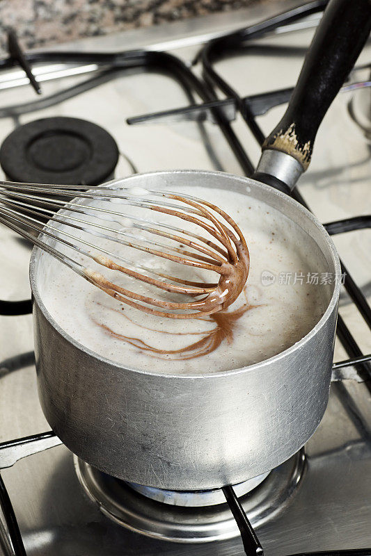 制作布丁:将巧克力搅入加热的浓稠牛奶中