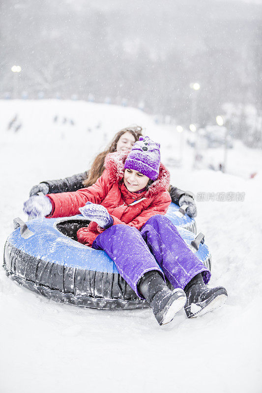 两个女孩穿着冬装，穿着雪衣