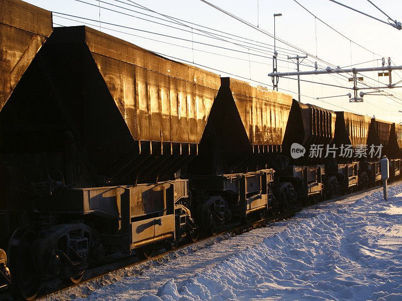 夕阳在铁矿石车上和雪地上闪闪发光