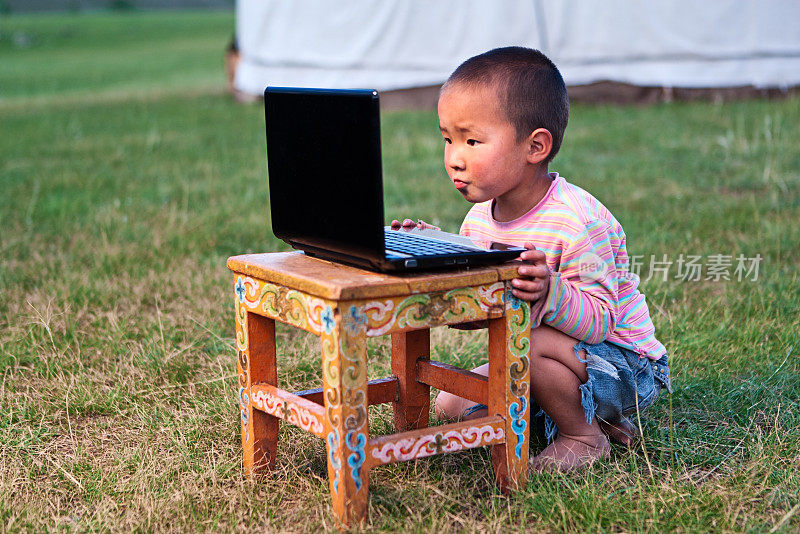 有笔记本电脑的蒙古小男孩