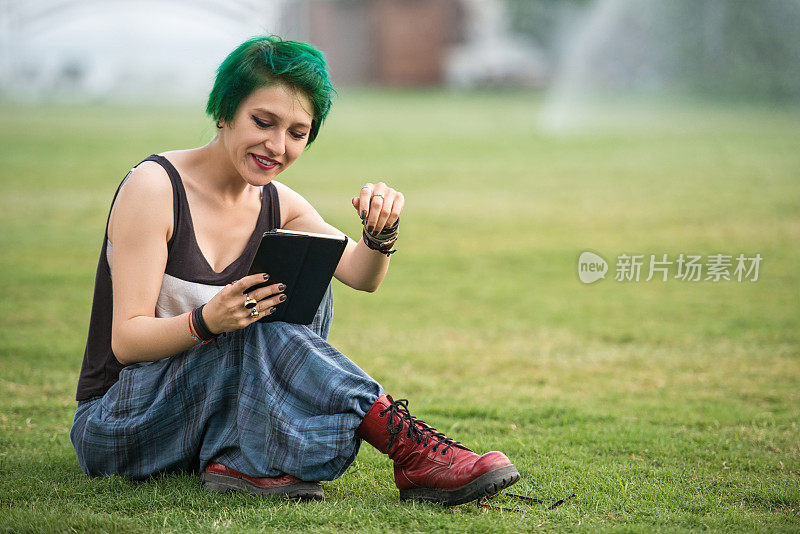 微笑的年轻女子在户外使用数码平板电脑