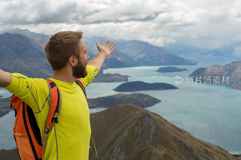 成功登上山顶，男人伸开双臂