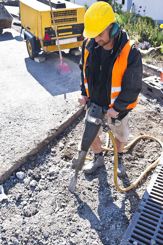 手持手提钻的道路工人