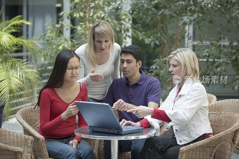 由四名多民族学生组成的小组，用手提电脑进行讨论