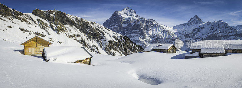 雪山小屋在田园诗般的冬季景观下的山峰全景