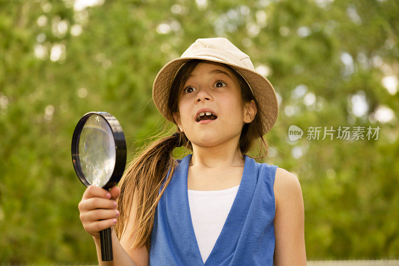 小学女孩喜欢发现自然。放大镜。