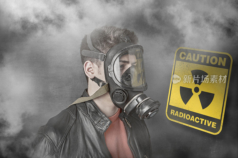 戴着防毒面具的男孩，反对核警告标志