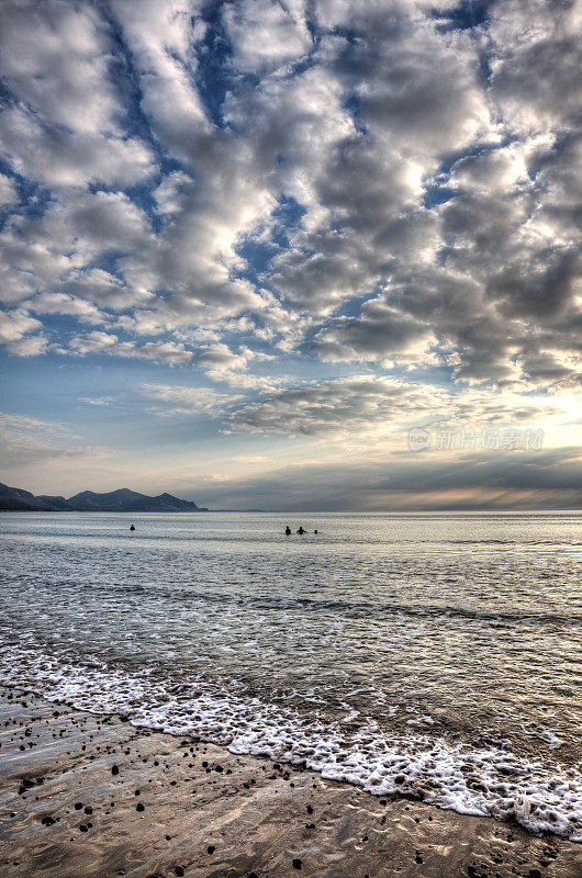 日落时分，人们在格温内思海岸游泳