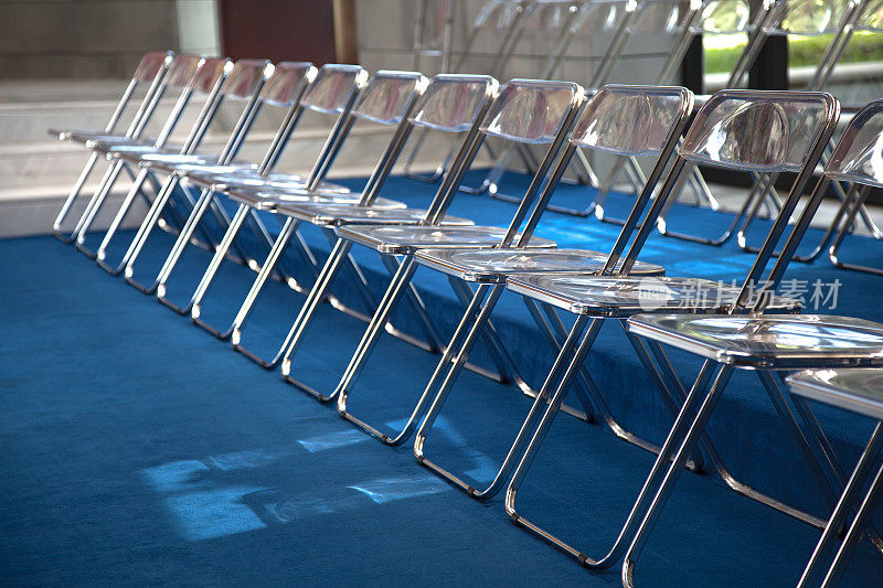蓝色地毯上的一排金属折叠椅
