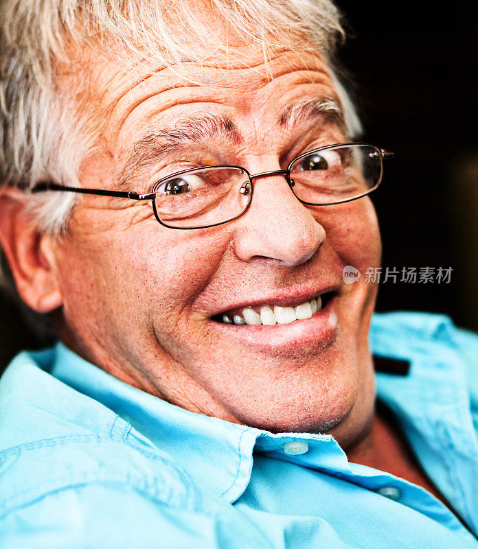 一位戴着眼镜的愉快的老人扬起眉毛，微笑着