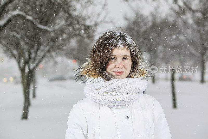 雪下穿着白色夹克的漂亮少女