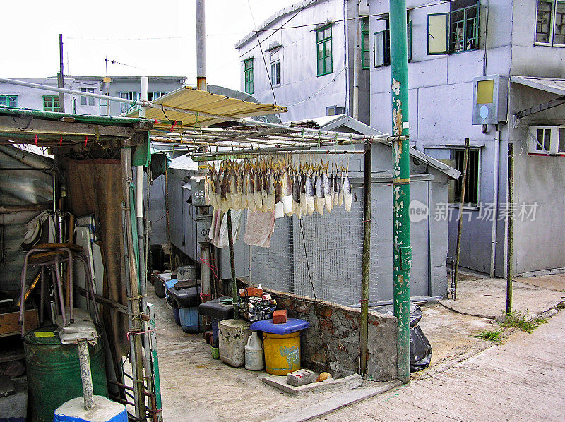 在渔村大澳(香港)，鱼挂在小建筑物之间的脚手架上
