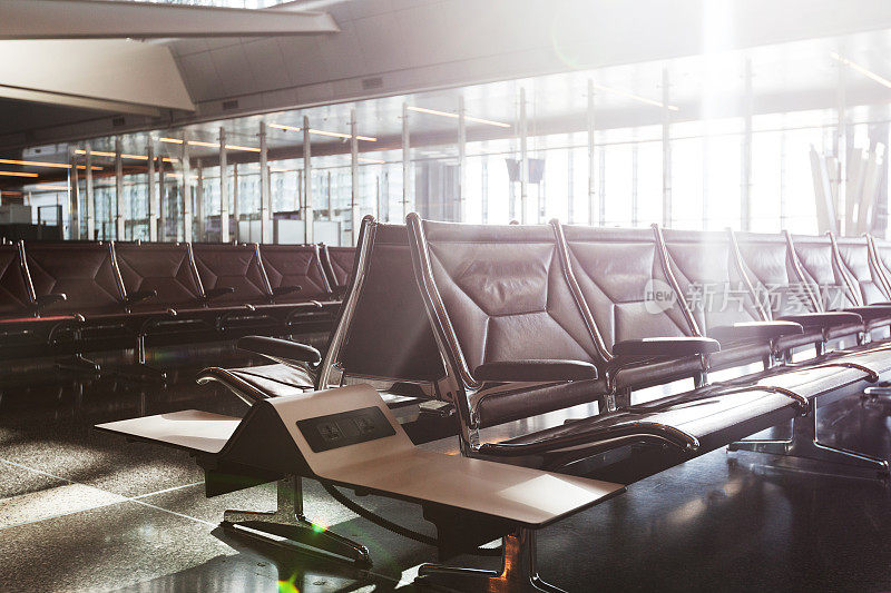 日落时分，现代化的机场航站楼配有黑色真皮座椅。