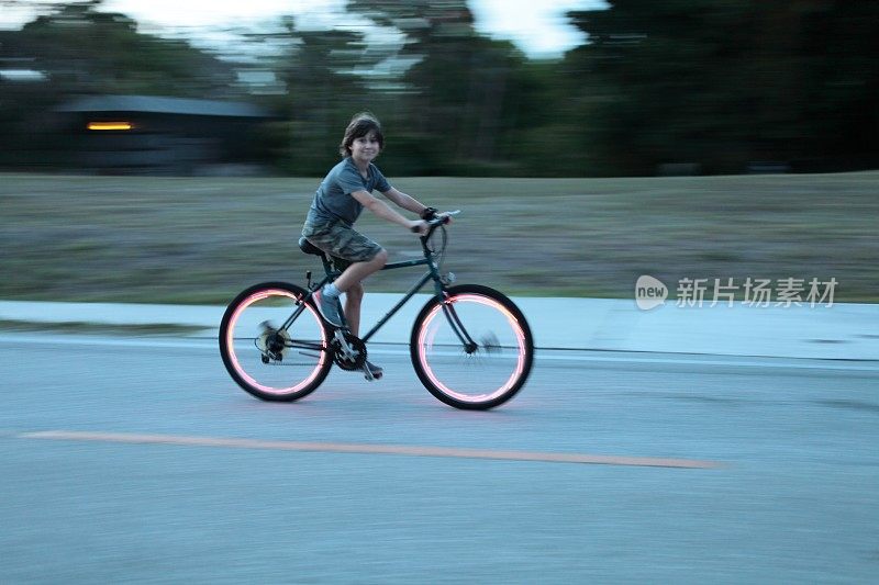 男孩骑自行车。自行车红灯。