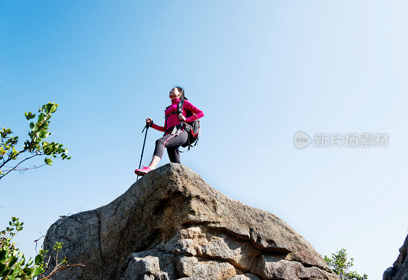 女背包客在山顶岩石的边缘