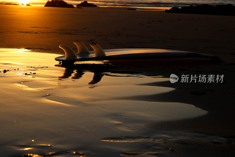 海滩上夕阳下的冲浪板