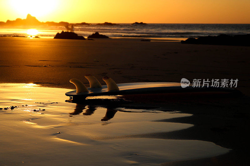 海滩上夕阳下的冲浪板