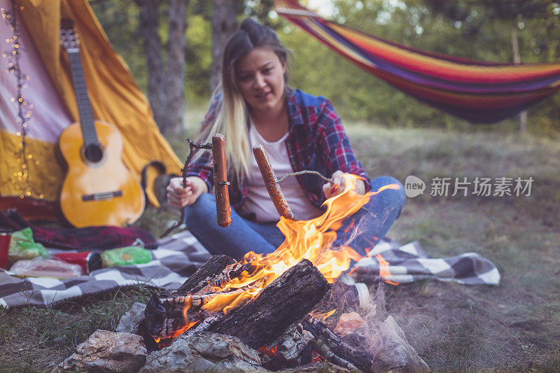 露营快乐的女人自然帐篷准备美味的香肠火