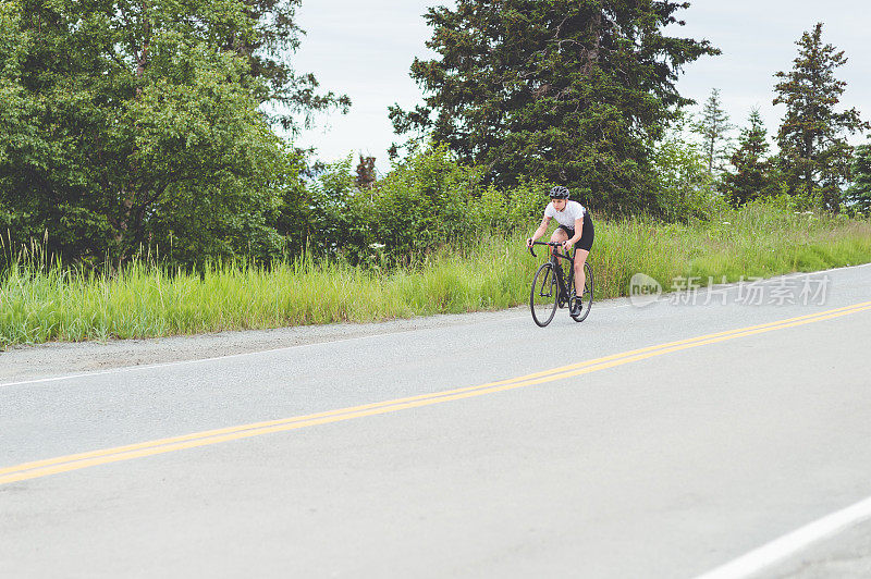 一名骑自行车的女性沿着乡村公路骑行