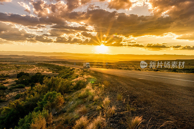 半卡车在州际公路黄昏与Cloudscape