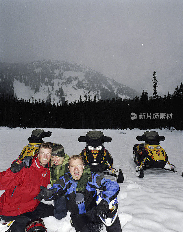 两个男人和女人坐在雪地摩托旁，肖像