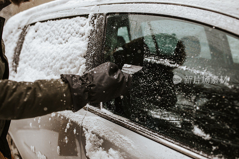 一名男子正在清理车上的积雪