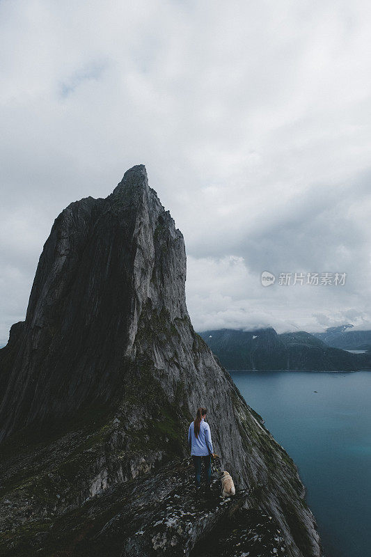 一个女人和一只狗在挪威的塞格拉山徒步旅行