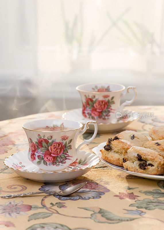 下午茶——葡萄干烤饼和用老式英式茶杯盛着的茶