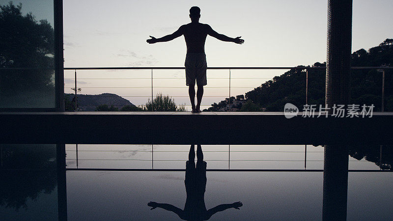 动态瑜珈流。在泳池边做瑜伽的男人。山的姿势