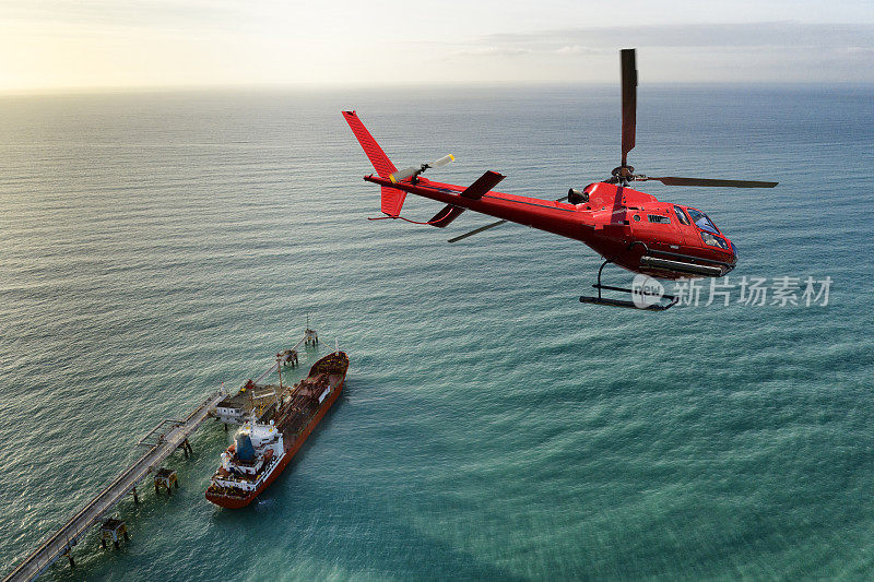 直升机飞过工业船。