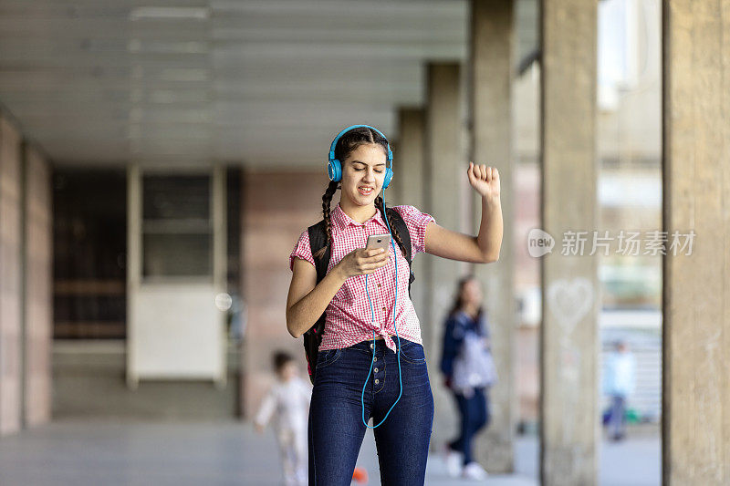 少女走在街上听着音乐