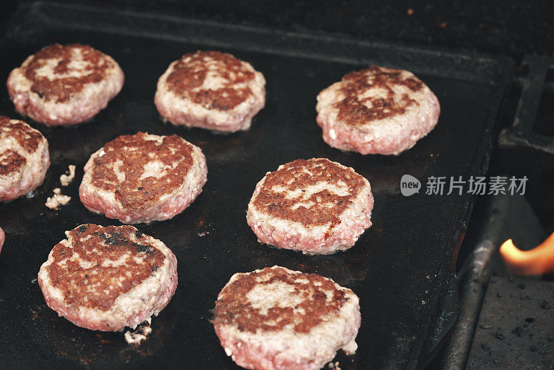 牛肉饼在烧烤架上准备汉堡