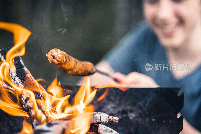 在户外野餐。在烧烤架上烤香肠