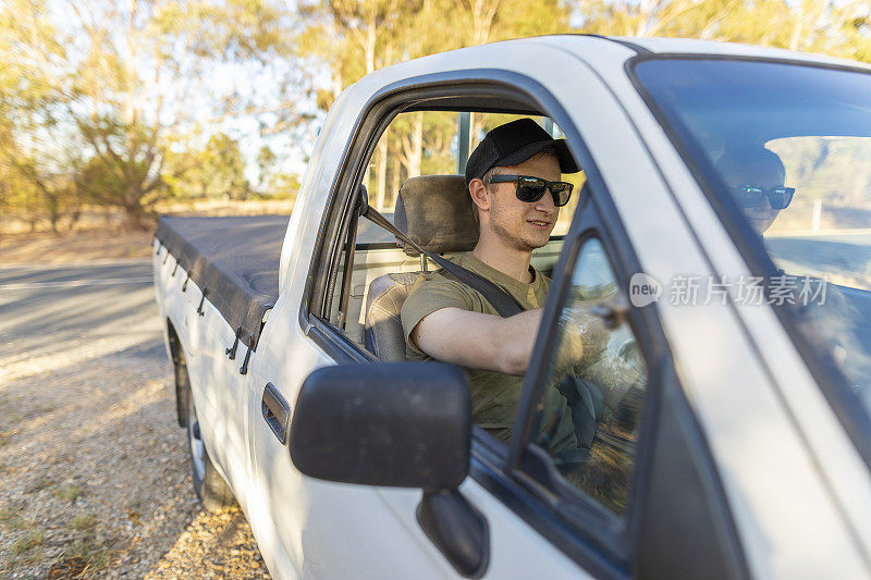 一个年轻人在一条土路上开车