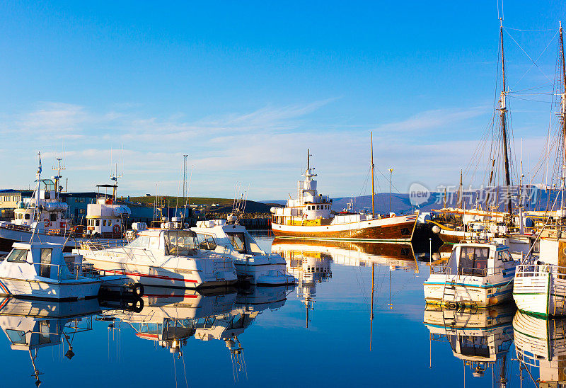 Húsavík，冰岛:清晨阳光明媚的港口里的小船