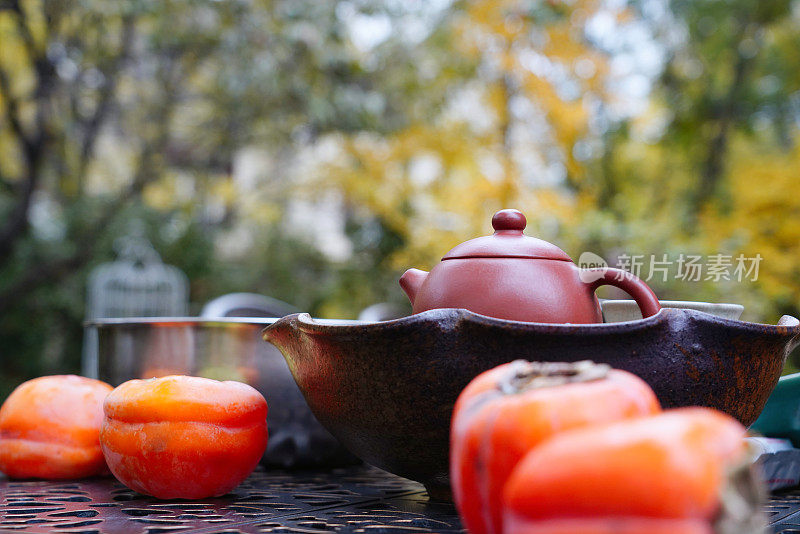 庭院桌子上的柿子和茶具