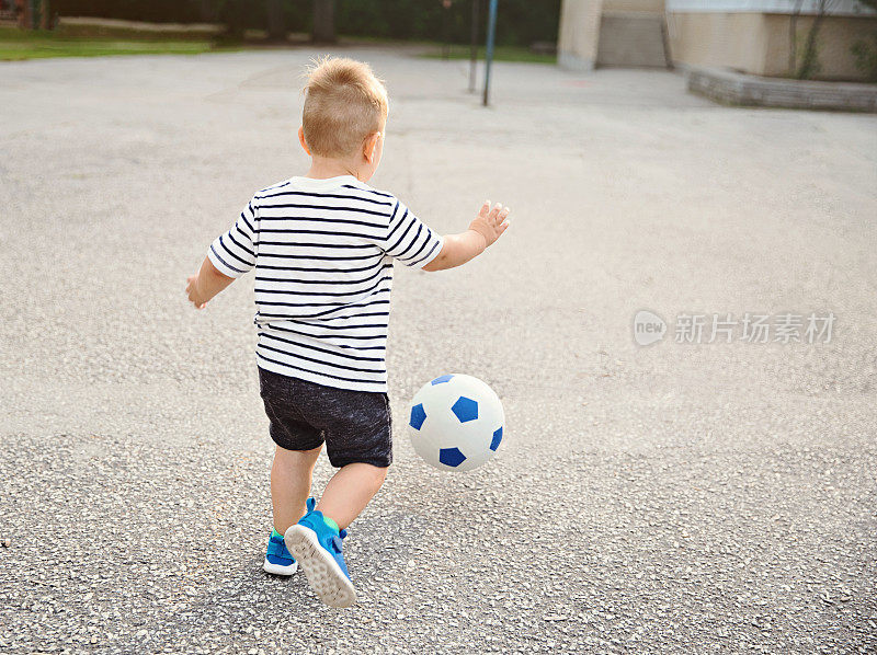 追逐足球的小男孩