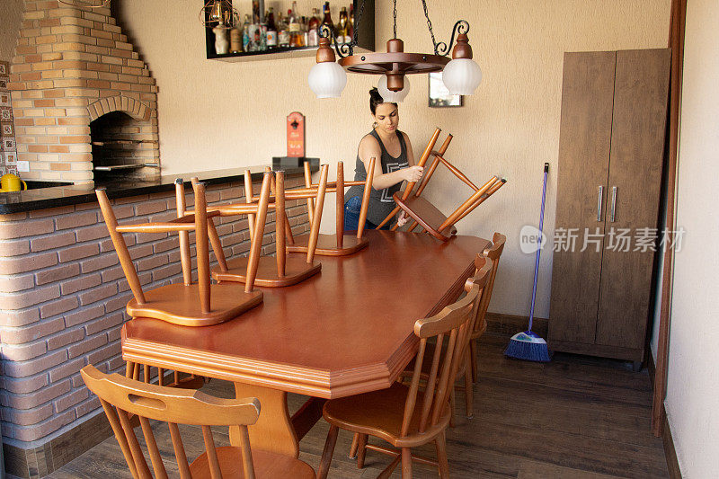 妇女用大木桌和八把椅子，烧烤和冰箱清洁房子的外部区域