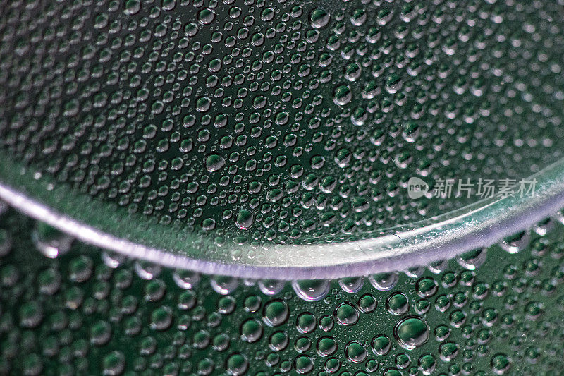 宏观水滴在曲面上投出绿色和银色的颜色
